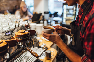 Fototapeta na wymiar Barista making hot drink in coffee shop, cappuccino brewing.