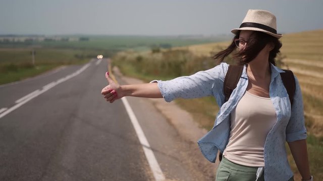 traveler with a backpack and a hat trying stop the car. tourist hitchhiking