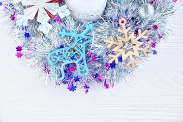 New Year 2020 flat lay from silver Christmas wreath with wooden toys and Christmas balls on white textured background, selective focus. Christmas and New Year flat lay with shiny decorations 