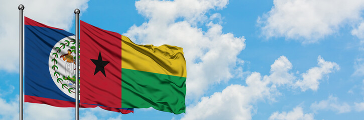 Fototapeta na wymiar Belize and Guinea Bissau flag waving in the wind against white cloudy blue sky together. Diplomacy concept, international relations.