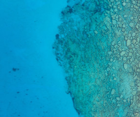 Obraz na płótnie Canvas An aerial view of the beautiful Mediterranean sea, where you can se the rocky textured underwater corals and the clean turquoise water of blue lagoon Agia Napa