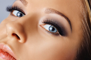 Woman face with eyes with long eyelashes and smokey eyes make-up. Eyelash makeup, cosmetics, beauty