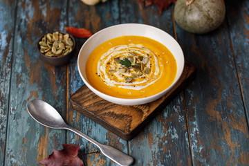 Vegetarian autumn pumpkin cream soup with seeds in white bowls. Pumpkin soup