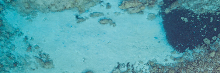 An aerial view of the beautiful Mediterranean sea, where you can se the rocky textured underwater corals and the clean turquoise water of blue lagoon Agia Napa