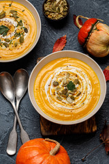 Vegetarian autumn pumpkin cream soup with seeds in white bowls. Pumpkin soup