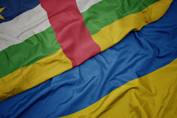 waving colorful flag of ukraine and national flag of central african republic.