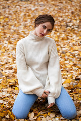 Young beautiful girl in blue jeans and gwhite sweater