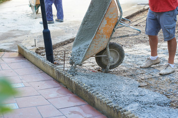  Construction workers working outdoors pouring concrete.