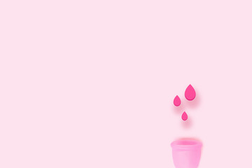 Top view of a pink menstrual cup on a color background. Products of female intimate hygiene period replacement pads and tampons