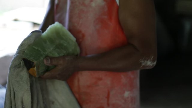 Slow motion shot of man drying polished semiprecious green onix. Close up of hands. Handcraft decoration. La Toma, San Luis, Argentina