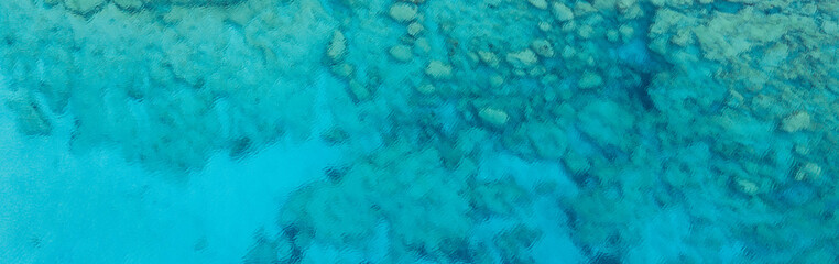 An aerial view of the beautiful Mediterranean sea, where you can se the rocky textured underwater corals and the clean turquoise water of blue lagoon Agia Napa