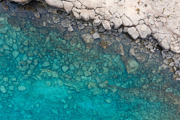 An aerial view of the beautiful Mediterranean sea, where you can se the rocky textured underwater corals and the clean turquoise water of blue lagoon Agia Napa