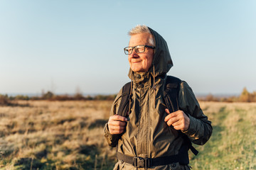Senior man trail hiking in a mountain forest