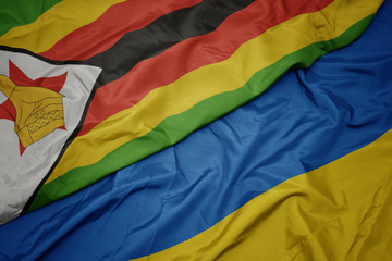waving colorful flag of ukraine and national flag of zimbabwe.