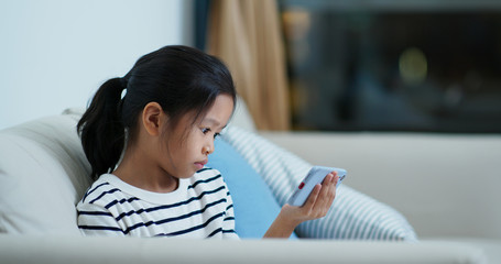 Little girl watch on cellphone at home