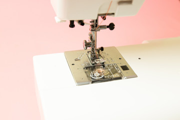 Close-up of a sewing machine on a pink background