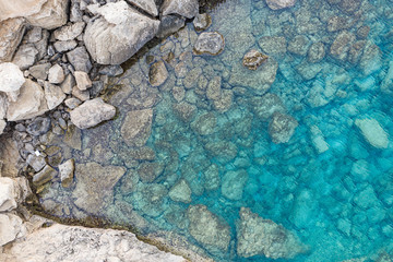 An aerial view of the beautiful Mediterranean sea, where you can se the rocky textured underwater corals and the clean turquoise water of blue lagoon Agia Napa