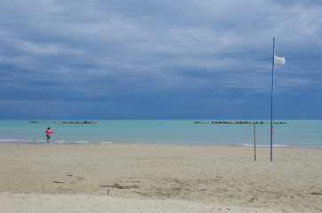 A photographer takes a dramatic storm on the Adriatic Sea in Roseto degli Abruzzi with green sea and black clouds, Abruzzo, Italy.