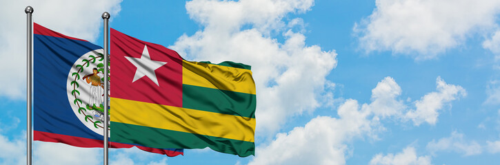 Belize and Togo flag waving in the wind against white cloudy blue sky together. Diplomacy concept, international relations.