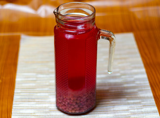 red juice in a glass, on a beige background