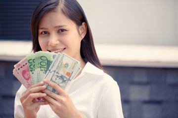 Asian women hold banknotes in many countries. Such as the United States, Euro, China