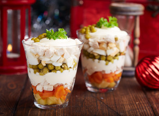 Layered Olivier salad with boiled vegetables in portion jar. Traditional Russian cuisine. 