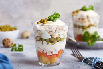 Layered Olivier salad with boiled vegetables in portion jar. Traditional Russian cuisine. 