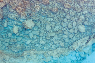 An aerial view of the beautiful Mediterranean sea, where you can se the rocky textured underwater corals and the clean turquoise water of blue lagoon Agia Napa