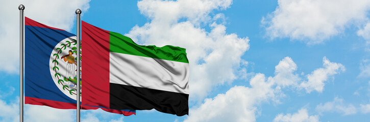 Fototapeta na wymiar Belize and United Arab Emirates flag waving in the wind against white cloudy blue sky together. Diplomacy concept, international relations.