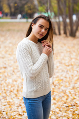 Close up portrait of a young beautiful girl in a white woolen sweater