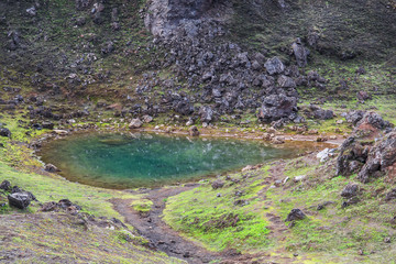 Obraz premium Emerald colored glacial lagoon in the midst of the surreal landscapes near Landmannalaugar along the Laugavegur hiking trail, Highlands of Iceland