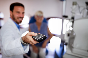 Optometrist examining senior woman in modern ophthalmology clinic