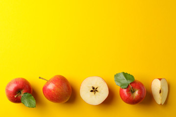 Flat lay with red apples on yellow background, space for text