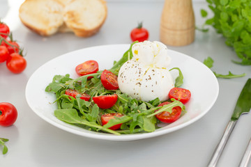 Fresh Salad with Italian burrata cheese, arugula, cherry tomatoes and olive oil. Healthy eating. Selective focus 
