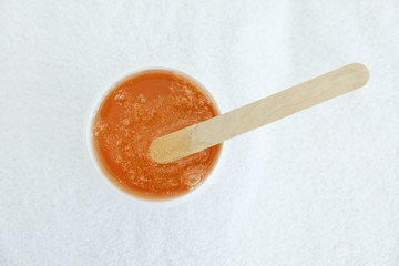 Liquid yellow paste for shugaring on white background. Depilation and body care