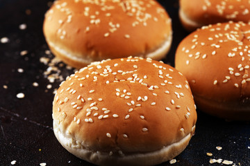 Fresh homemade burger buns with sesame on dark background