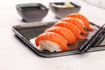 close up of sashimi sushi set with chopsticks and soy - sushi roll with salmon and sushi roll with...