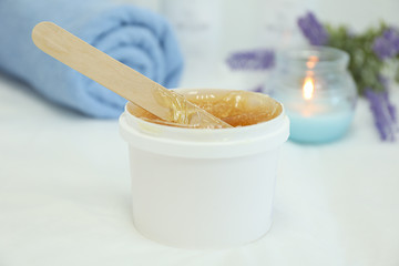 Concept with liquid yellow paste for shugaring on white background, space for text