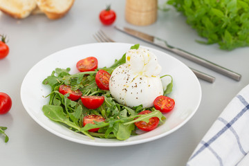 Fresh Salad with Italian burrata cheese, arugula, cherry tomatoes and olive oil. Healthy eating. Selective focus 