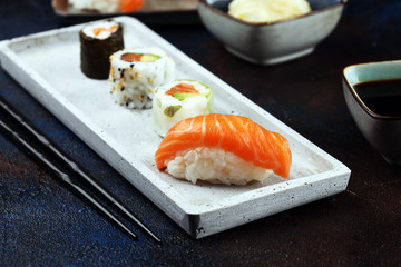 close up of sashimi sushi set with chopsticks and soy - sushi roll with salmon and sushi roll with smoked eel