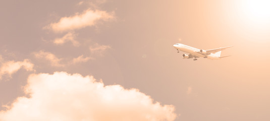 Plane on the background of the sky with clouds in the evening. Transport, travel.