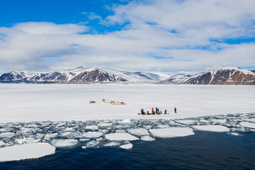 Aerial drone photo of tourists visit the floe edge near Sirmilik National Park in Nunavut, Canadaa © Colin