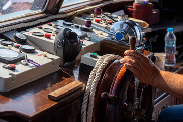 Control panel in tourist boat with hand on the steering wheel © kalpis
