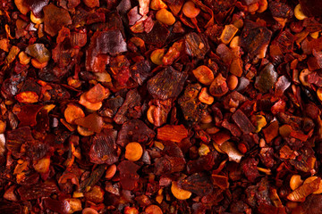 Crushed dried chili pepper red background, close-up macro. Concept, copy space.