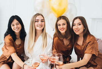 Bachelorette Weekend. bridesmaids posing into camera, they drinks alcohol and enjoing hen party