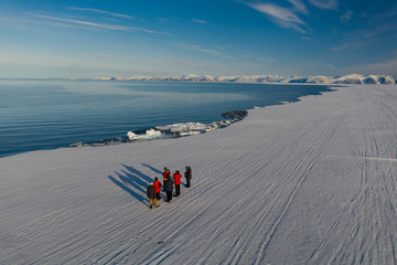 Aerial drone photo of tourists visit the floe edge near Sirmilik National Park in Nunavut, Canadaa