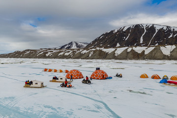 Aerial drone photo of tourists camping on the floe edge near Sirmilik National Park in Nunavut, Canadaa © Colin