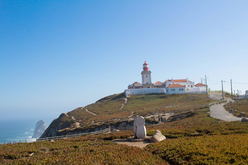 Fototapeta na wymiar Beautiful view of the beach, lighthouse and ocean on the sunny day. Cape Roca. Portugal.