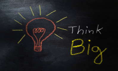  word think big and light bulb drawn with colorful chalk on a blackboard, business concept