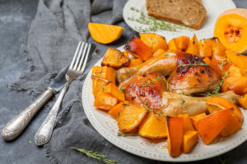 Chicken thighs and baked pumpkin and orange slices.
